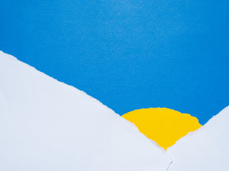 Abstract Torn Paper Sunrise Landscape with Yellow Sun and Blue Skyの写真素材