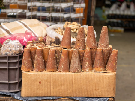 Piloncillo, a traditional unrefined cane sugar, in a cone shape in street marketの写真素材