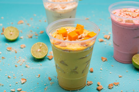 Handle charlotte in plastic cup on light blue background. Frozen mango pie.の写真素材