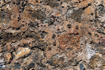 Close-up of volcanic rock texture wall in brown and black tonesの写真素材