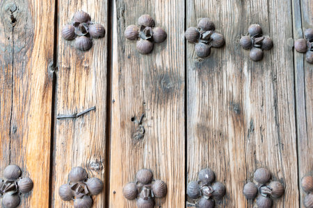 Antique rustic wooden door panel with decorative metal floral detailsの写真素材