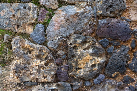 Rustic Volcanic Rock Wall Texture with Moss and Natural Detailの写真素材