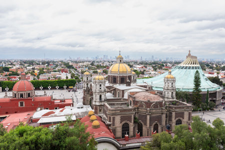 A panoramic high angle cityscape view of the Basilica of Guadalupe and the Mexico City skyline on a cloudy day.の写真素材