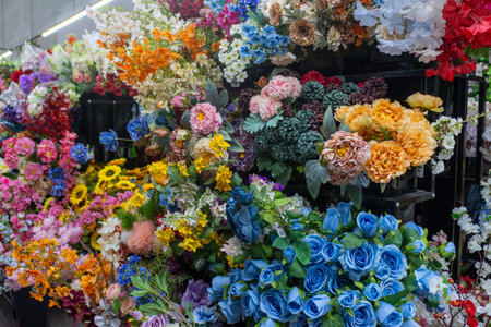 Colorful and vibrant assortment of artificial floral arrangements on display.の写真素材