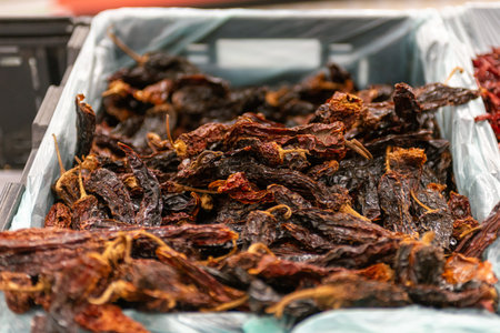 Close-Up Dry Chili Peppers Heap in a Container at Marketの写真素材