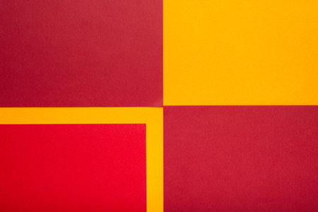 A geometric arrangement of red and yellow colored paper shapes