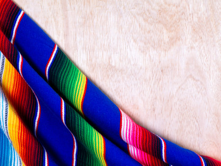 Vibrant Woven Serape Style Textile on Light Wooden Background Texture