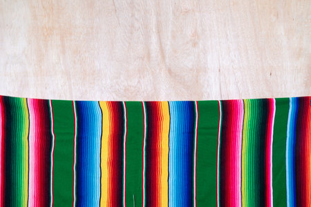 Vibrant Woven Serape Style Textile on Light Wooden Background Texture