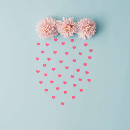 Pastel pink flowers and rain made with hearts. Valentines or woman's day concept. Minimal aesthetic.の写真素材