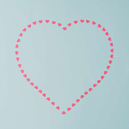 Heart shape copy space with pink hearts. Valentines day concept on pastel blue background. Minimal flat lay.の写真素材