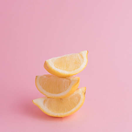 Fresh lemon slices close up on pink background. Trendy summer pattern. Fruit minimal concept.の写真素材