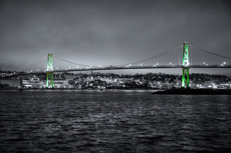 A night view of the Angus MacDonald Bridge in Halifax Nova Scotia with the bridge arches lit up in green.の写真素材