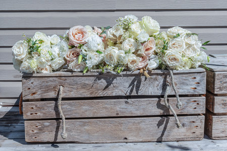 The bridal bouquets of the bride and the bridesmaids sitting on a rustic wooden chest with woven brown rope embellishments.の写真素材