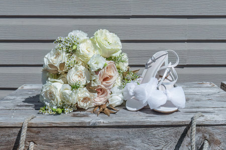 Ruffle-style chiffon fabric wedding shoes next to the beautiful pastel-colored wedding bouquet.の写真素材