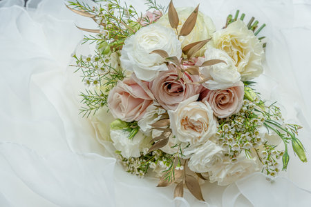 A stunning soft pastel colored wedding bouquet arrangement with pearls and ivory ribbon strapped stem.の写真素材