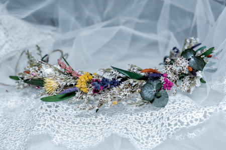 The bridal floral wildflower crown lying on a lacey white veil.の写真素材
