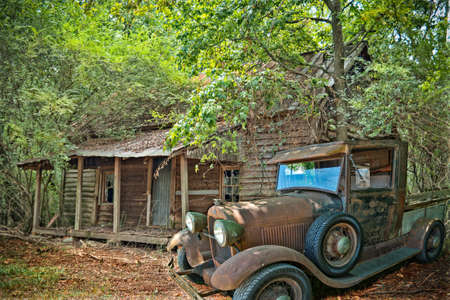 Bostwick, Georgia/USA-09/17/16 Hidden in the woods off a back road in rural Georgia is a rusty model T Ford truck sitting in front of an old abandoned cabinのeditorial素材