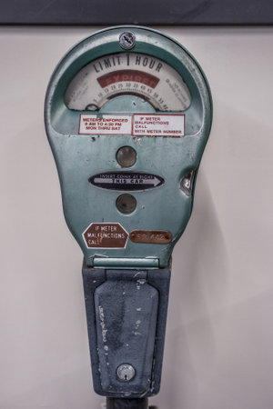 An old vintage worn and used parking meter out of service on display only indoors closeupの写真素材