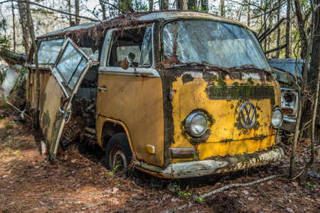 White, Georgia USA - March 28, 2018  A bright yellow broken and rusty Volkswagon bus or van left in...