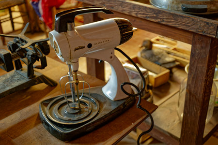 Clarkrange, Tennessee USA - March 25, 2023  Old antique Sunbeam mixmaster on a table with a pair of beaters and a tattered power cord surrounded by other junk closeup view indoorsのeditorial素材