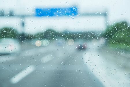 A car is driving on the road in the rainの写真素材