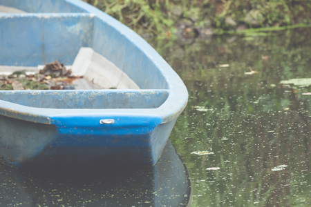 An old boat in the dirty waterの写真素材