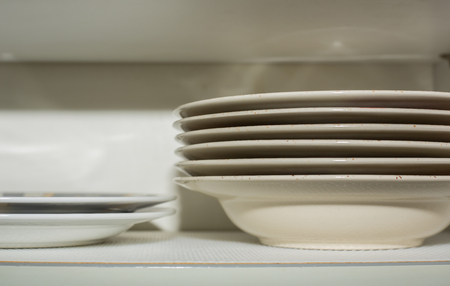 Stacked plates in the kitchen cupboardの写真素材