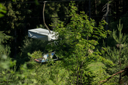 A chairlift goes up and down the mountainの写真素材