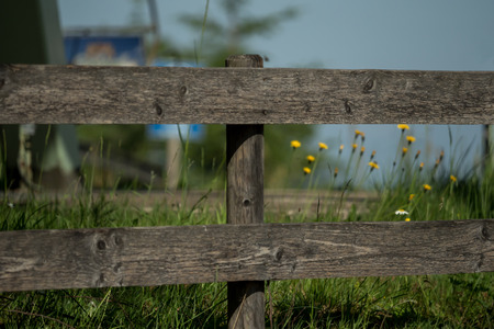 A wooden fence on a blooming meadowの写真素材