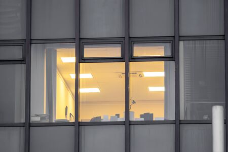 An office lights up in a building after workの写真素材