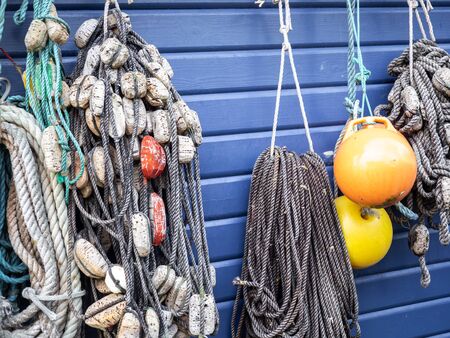 Fishing nets and ropes hang outside on the house wallの写真素材