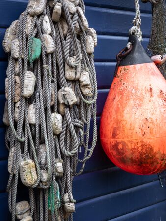 Fishing nets and ropes hang outside on the house wallの写真素材