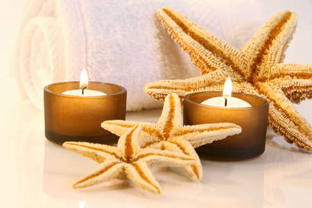 Little brown candles, towel and starfish with a warm glowの写真素材