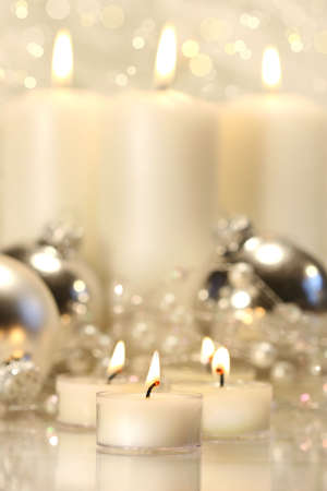 White votive candles with tall candles in backgroundの写真素材