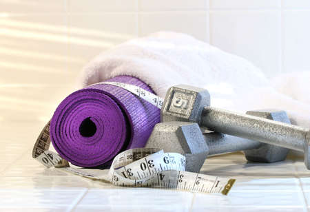 Exercise mat with weights on white tile floorの写真素材