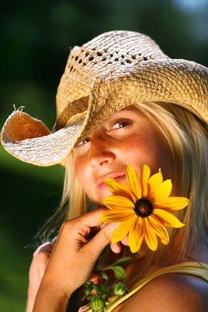 Young woman holding a big yellow daisyの写真素材