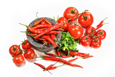 Assortment of red peppers and tomatoes on white backgroundの写真素材