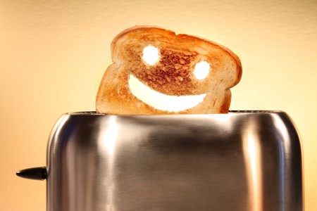Toast with smiley face in toaster  on counterの写真素材