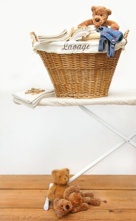 Laundry basket with teddy bears on pine floorの写真素材