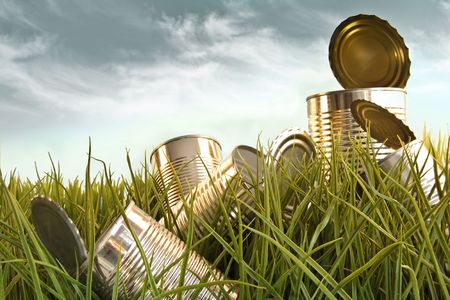 Discarded aluminum cans in tall grass against skyの写真素材