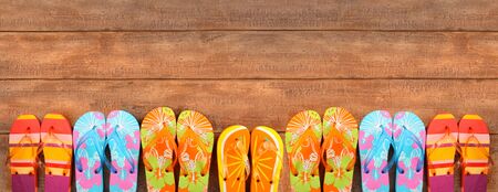 Brightly colored flip-flops on wood deckの写真素材