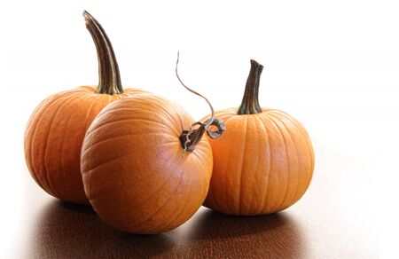 Colorful pumpkins on wood table with white background