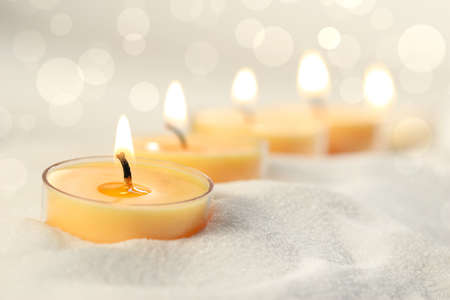 Votive candles in sand lit and arranged for ambianceの写真素材