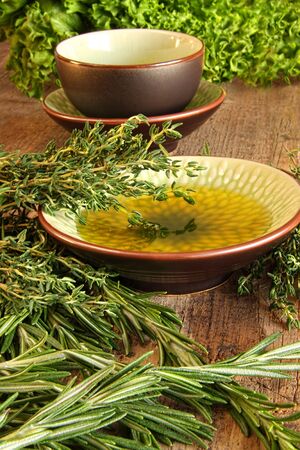 Fresh herbs with olive oil on wooden cutting board の写真素材