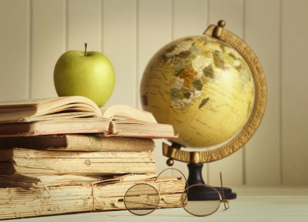 Old books with apple and globeの写真素材