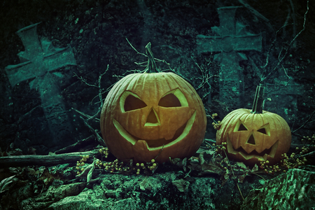 Halloween pumpkins in graveyard at nightの写真素材