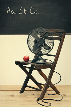Old fan with apple on chair in school roomの写真素材