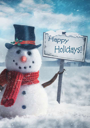 Snowman holding wooden sign with holiday greetingsの写真素材