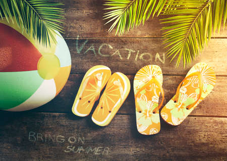 Summer sandals with beach ball on wood backgroundの写真素材