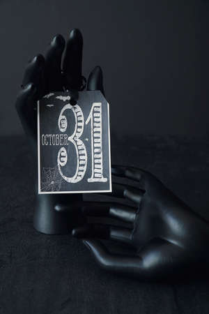 Black hands holding a Halloween cardの写真素材